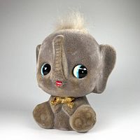 Front angled view of vintage flocked elephant coin bank toy showing detailed facial features and bow tie.