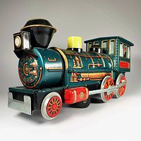 Image showing detailed front and side view of metallic green and red tin toy train with chimney, headlight, and wheels visible.