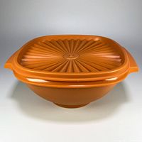 Front angle showing vintage Tupperware container bowl with lid in harvest orange, highlighting side handles and bowl shape.