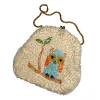 Front view of cream-colored beaded clutch purse with colorful owl beading and gold-tone chain strap.