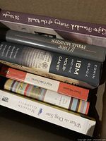 Box of books showing spines with titles and authors including Edwin Black, Malcolm Gladwell, Stuart McLean.