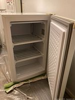 Open front view showing two wire shelves and bottom compartment