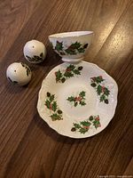 Set of Christmas-themed Royal Grafton china including plate, sugar bowl, salt and pepper shakers placed on wooden surface