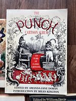 Front cover of The Punch Cartoon Album showing detailed black and red cartoon artwork and title.