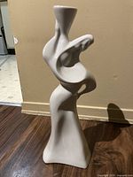Full view of the white porcelain modern abstract sculpture showing its overall shape and size.