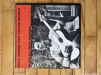 Front cover of the vinyl record sleeve showing Pete Seeger playing guitar in black and white with red text.