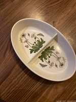 Oval divided dish with floral and insect prints on the inside, no visible chips or defects.
