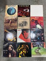 Overview photo showing all 12 classic rock vinyl records arranged in a grid on the floor.