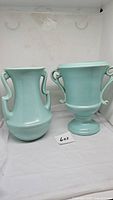 Two turquoise pottery vases side by side showing overall shape and double handles