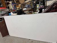 White rectangular table surface showing minor marks and stains.