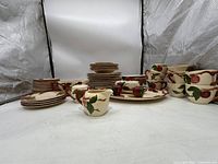 Full set arranged showing multiple cups, plates, and saucers along with serving pieces, highlighting quantity and style.