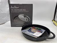 Box of Jean-Patrique The Whatever Pan with the griddle pan and glass lid beside it.