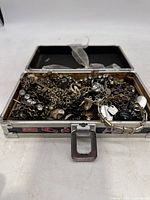 Top view of the metal case filled with assorted jewelry chains and pendants.