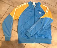 Blue Adidas zip-up sweatshirt with orange and light blue sleeves, Adidas trefoil logo embroidery on the chest.