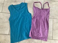 Front view of both tanks laid flat, showing teal v-neck tank and heathered purple spaghetti strap tank