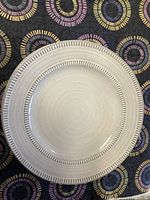 Top view of one pale gray/blue luncheon plate showing decorative rim.