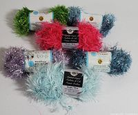 Top view of all six yarn skeins arranged in a circular layout showing color variations and brand labels.