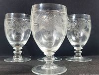 Front view of four vintage Crystalex 'Thistle' pattern crystal wine glasses showing etched floral pattern, bowl shape, and stems.