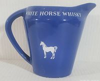 Front view of the blue ceramic White Horse Whisky pitcher with white horse logo and lettering.