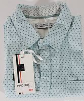 Folded men's short sleeve shirt with visible tags, light blue with dark blue dots