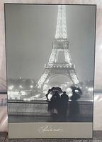 Full view of the framed black and white photo print showing Eiffel Tower at night and people silhouetted in foreground under umbrella.
