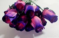 Close-up view of the cluster of twelve pink and purple wooden roses showing petal color transition and texture