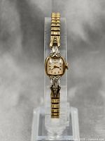 Full view of front of vintage 1959 Bulova ladies watch showing gold and silver tone decorative case and bracelet.