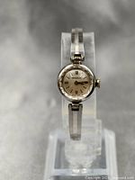 Front view of Caravelle ladies mechanical watch showing the entire watch on a display stand with silver-tone bracelet and round face.