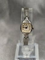 Full length front view of vintage Caravelle ladies watch on stand showing watch face and band.