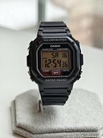 Front view of Casio F-108WH black digital watch showing time, day, date, and various function markings on the face including Illuminator and Water Resist.