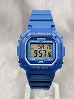 Blue Casio F-108WH digital wristwatch showing time and date on LCD screen, with clear markings and buttons, displayed front and close-up.