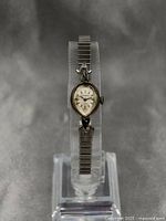 Full view of gold plated Girodau Swiss ladies watch on display stand showing the entire watch and metal expandable band.