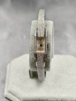 Front view of the Wakmann Geneve ladies mechanical cuff watch on a display stand, showing rectangular dial and band texture.