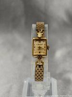 Front full view of the vintage 10k gold filled Crest ladies mechanical watch on a display stand, showing the rectangular case and link bracelet.