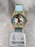 Front view of vintage Mickey Mouse mechanical watch with light blue leather strap and gold-tone bezel