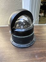 Front view of the Airguide nautical compass showing its domed glass top, black cast aluminum base, and labeled cardinal directions on the dial.