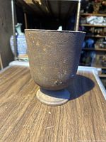 Full view of cast-iron mortar showing textured surface and patina