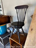 Full side view of the antique Victorian piano chair highlighting turned legs and carved claw feet.