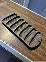 Full view of the cast iron cornbread pan with six corn-shaped molds on a wooden surface.