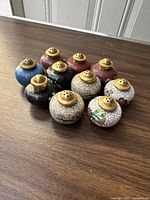 Overview image of 10 Chinese cloisonné salt and pepper shakers arranged in two rows, showing different colors and sizes.