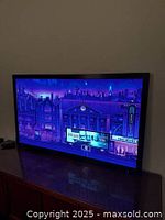 Front view of the TV screen turned on displaying a cityscape image.