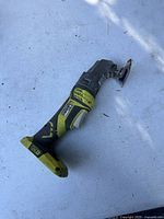 Side view of Ryobi P246 multitool showing overall shape and attached cutting blade.
