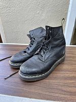 Front view of vintage Dr. Martens black leather boots showing laces and toe area with scuffs.