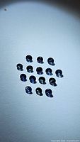 15 round blue sapphire gemstones arranged on white surface