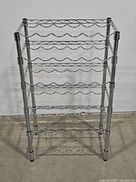 Front view of solid metal shelving unit designed to hold bottles.