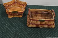 Photo of two Longaberger baskets side by side: star-shaped basket with protector and rectangular red traditions basket.