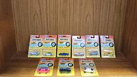 Photo shows eight Matchbox cars in original blister pack display on wooden surface.