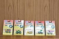 Five Matchbox construction vehicles in original packaging arranged in a row showing front blister cards.