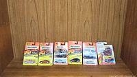 Six Matchbox Superfast die-cast cars in original blister pack including Mustang, Ferrari, Dodge, Aston Martin, Isuzu Amigo, and Mercedes Benz.