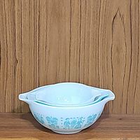Three Pyrex mixing bowls nested and stacked together showing turquoise Butterprint design